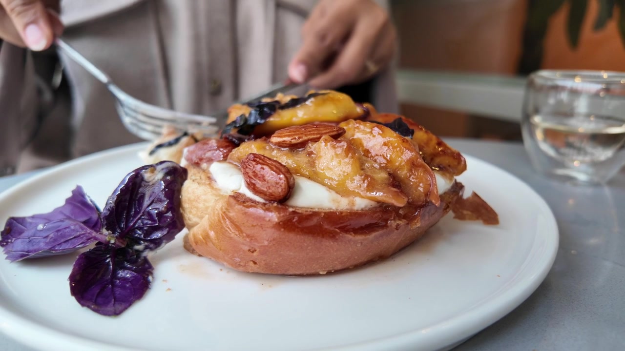 Person Eating Gourmet Toasted Bread with Fruit and Nuts