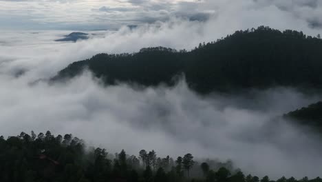 Vista-Aérea-De-Drones-Sobre-Las-Montañas-En-Las-Exuberantes-Nubes-Verdes-De-Lluvia-Cubren-La-Selva-Tropical-Durante-La-Temporada-De-Lluvias-En-México