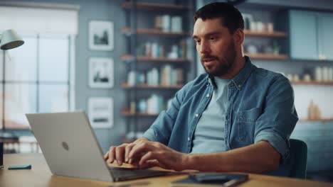 handsome caucasian man talking on video call on laptop computer while sitting on a sofa in stylish living room. freelancer working from home. browsing internet, drinking coffee from a mug, having fun.