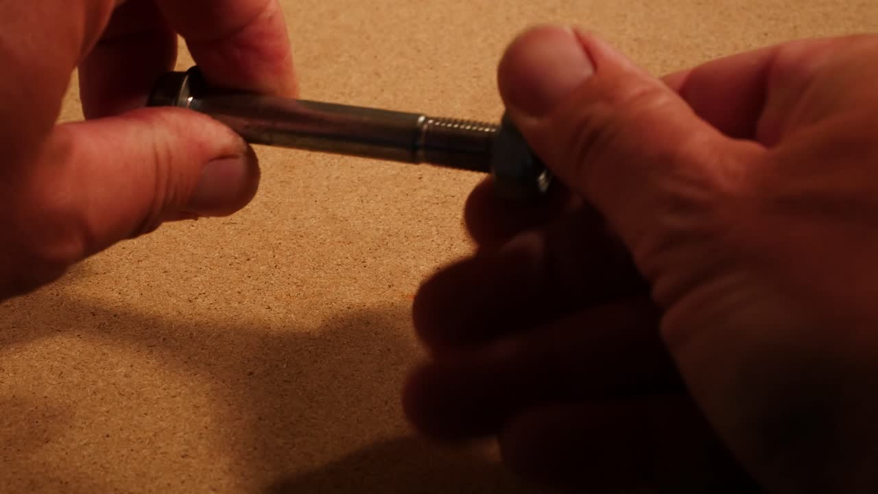 atornillar un gran tornillo en un ambiente oscuro