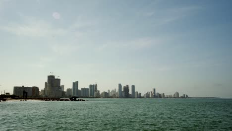 sea by cartagena with distant skyscrapers on clear day