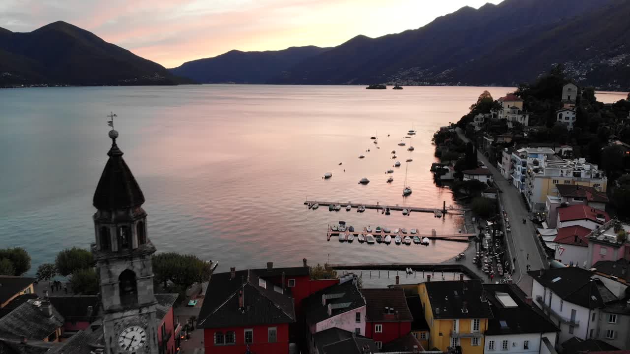 스위스 아스꼬나(ascona) 지붕 위의 공중 비행은 알프스 뒤의 보트와 화려한 일몰 노을을 볼 수 있는 마조레 호수(lago maggiore) 해안을 향한 교회 탑 옆에 있습니다.