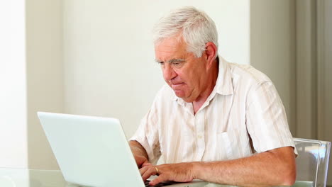 Senior man using laptop at the table