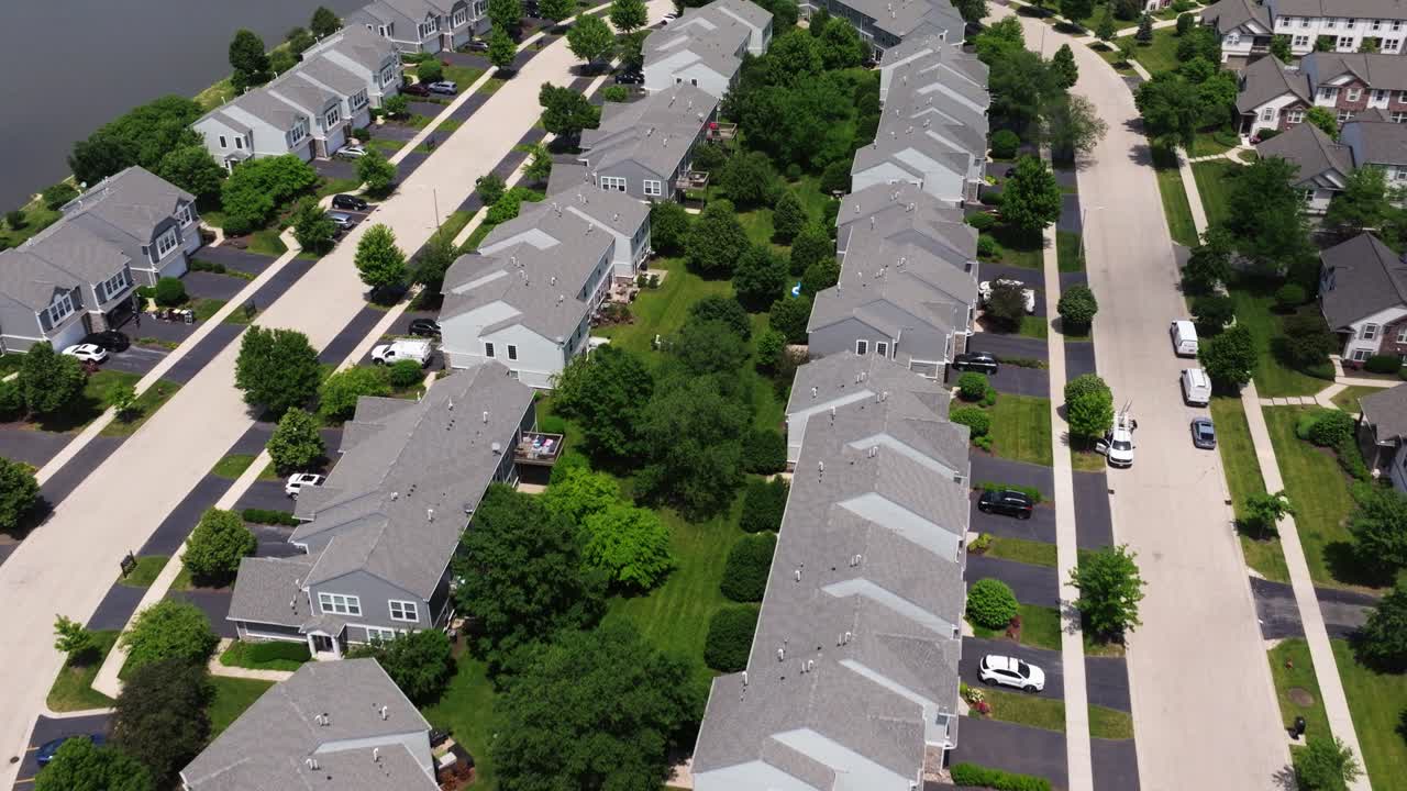 Curving streets and houses in an American multifamily suburb, townhome condo with trees, aerial