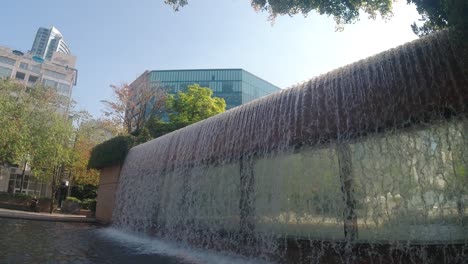 2-2 vistas panorámicas súper lentas hacia el exterior del edificio moderno de la ciudad con cascadas y piscina para despertarse para lavarse los pies durante los calurosos días de verano de refrescante refrescarse junto a las monedas del estanque escalonado de piedra exterior de mármol