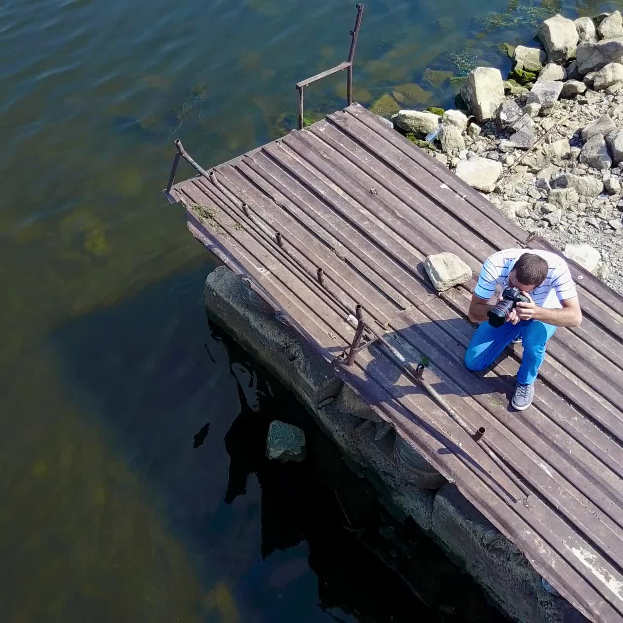 Man Taking Photos Near Pond