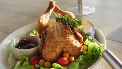 Video-of-healthy-appetising-meal-with-roast-chicken,-sauce-and-salad-on-wooden-dinner-table