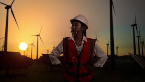 female engineer at a wind and solar farm at sunset