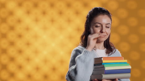 portrait of stern woman holding stack of books doing stop sign gesturing