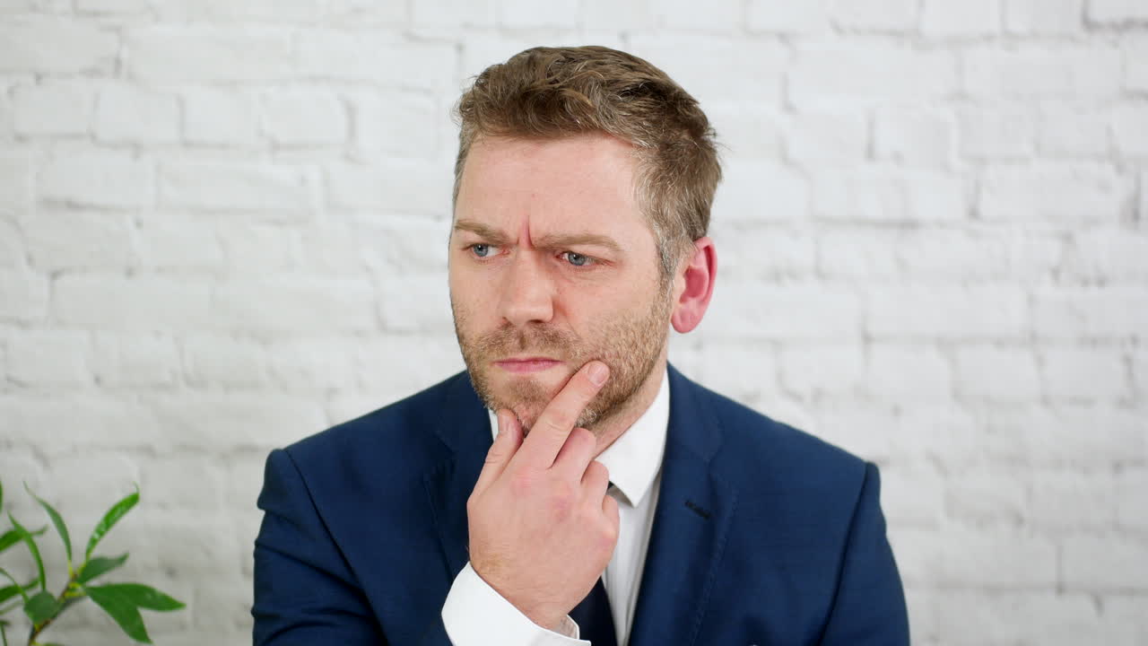 un hombre de negocios confundido pensando en una solución a un problema en una oficina