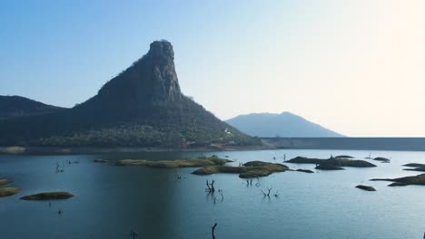 aerial shot of the engineering marvel that is karamchat dam, with water flowing and distant hills in the background.