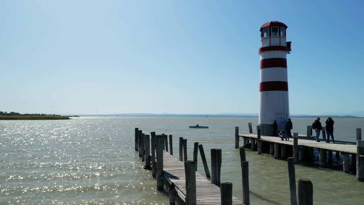 Aerial drone shot of a lighthouse on a lake. Camera moving forward.