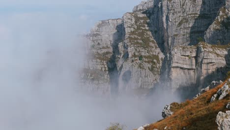 Aerial-Rising-Shot-From-Side-Of-Mountain-With-View-Of-Dramatic-Misty-Clouds-In-Bergamo-Alps