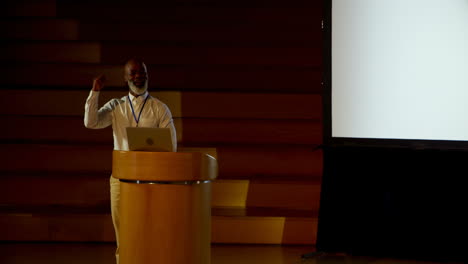 Mature-African-american-businessman-speaking-at-podium-in-auditorium-4k