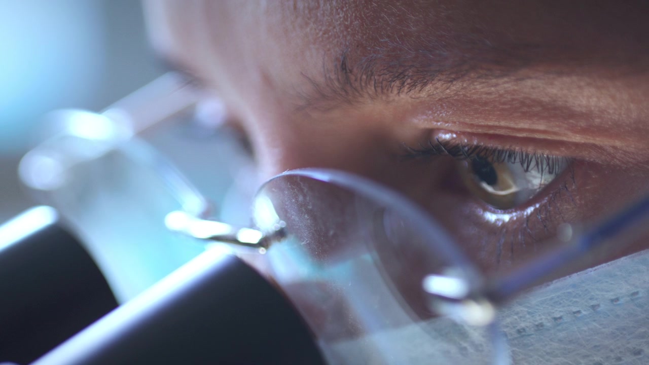 Extreme Close Up of Female Scientist Eyes Using Professional Microscope