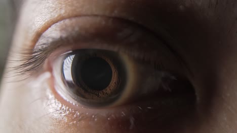 close up select focus shot - human eye as the person blinks and the pupil contracts and expands - observation concept