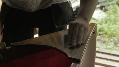 Sanding-down-a-layer-of-varnish-canoe-bow