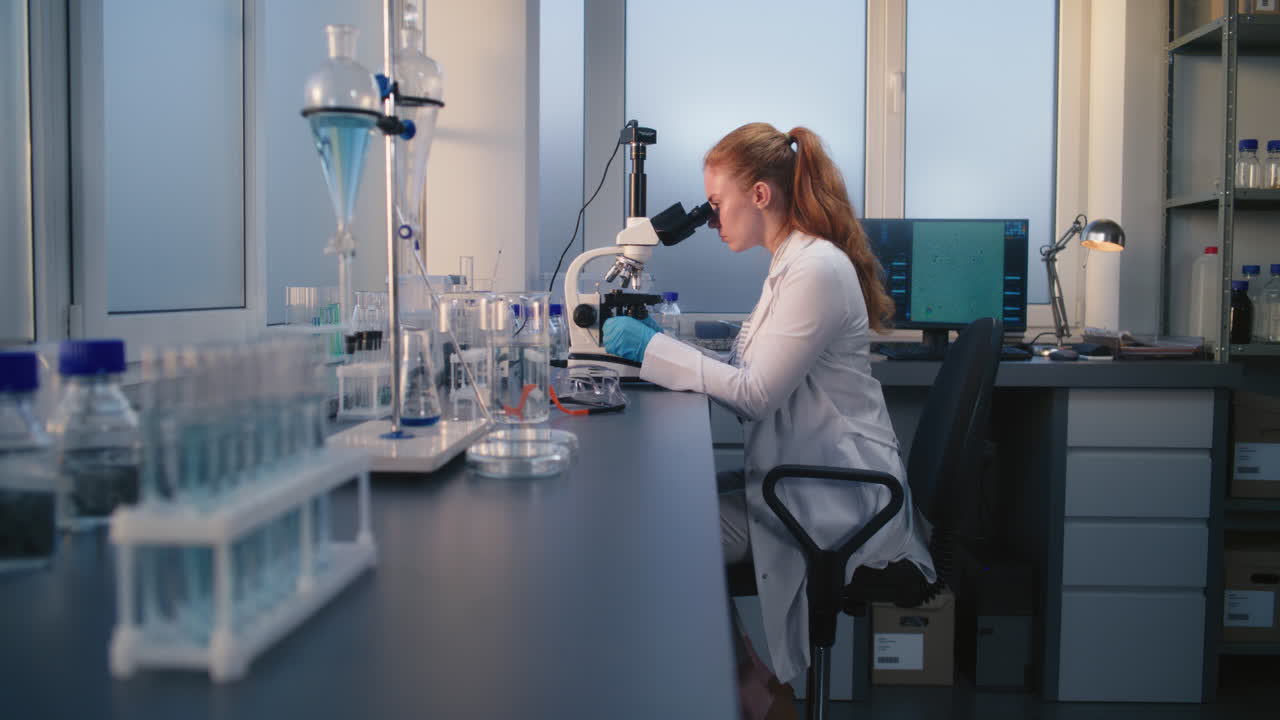 ученый использует микроскоп в лаборатории