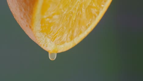 an orange half is dripping juice slowly