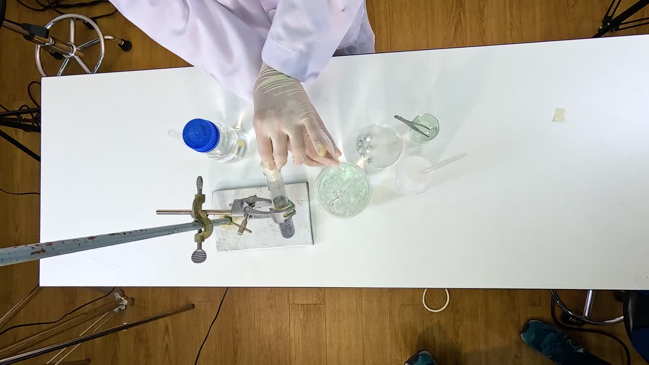 A scientist conducts a thermal decomposition experiment with copper carbonate, showcasing chemical reactions and laboratory techniques