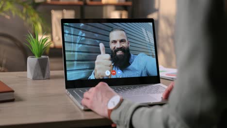 Female-Having-Video-Call-With-Male-Friend-While-Sitting-At-Desk-In-Office