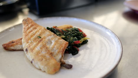 crisp grilled fillet with a side of herb-infused potatoes and greens