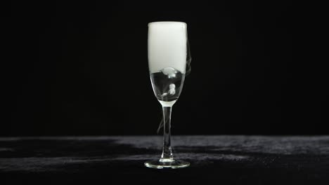 dry ice effect in a champagne flute on a black background