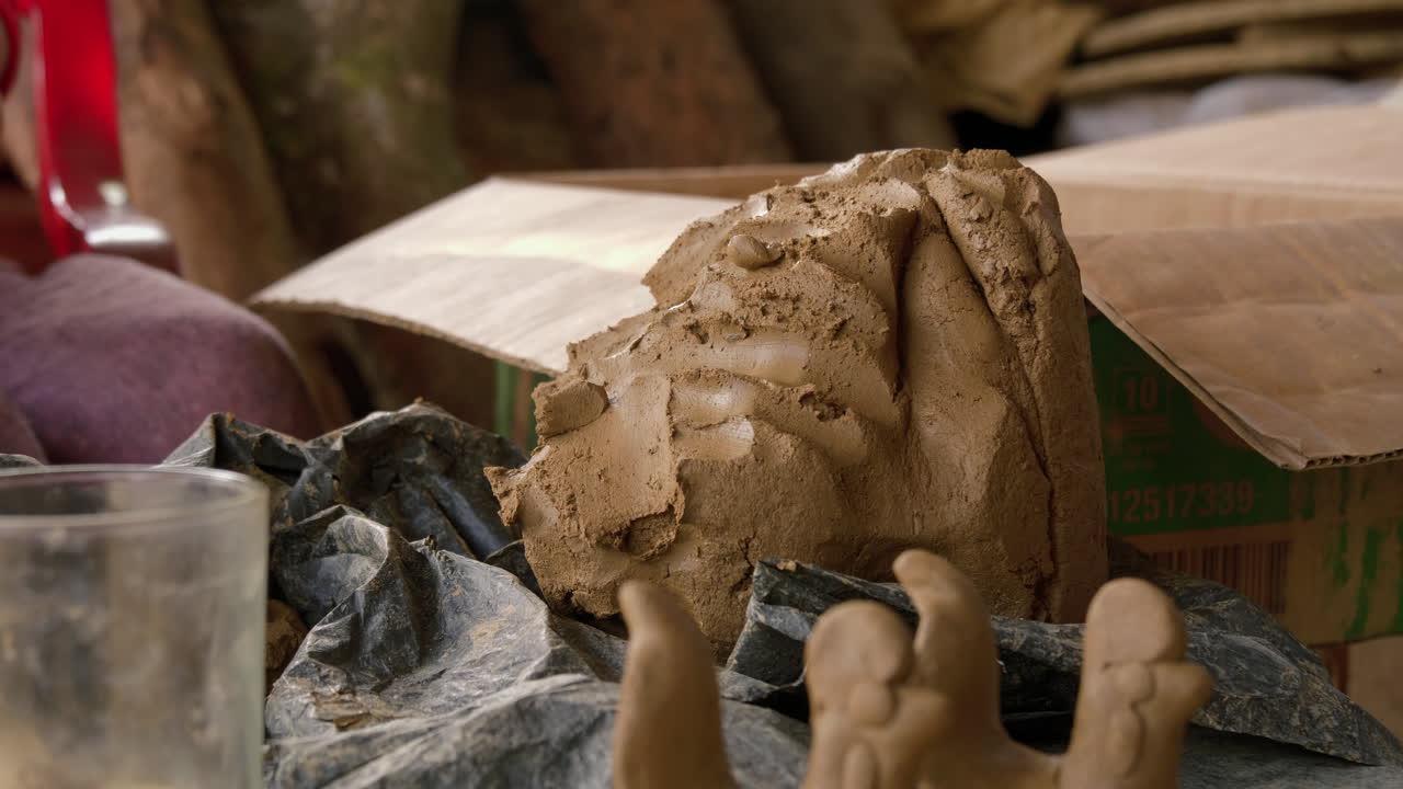 un artesano de thanh ha elabora hábilmente figuras de animales tomando arcilla de un bloque húmedo, mostrando la industria local del turismo y los souvenirs.