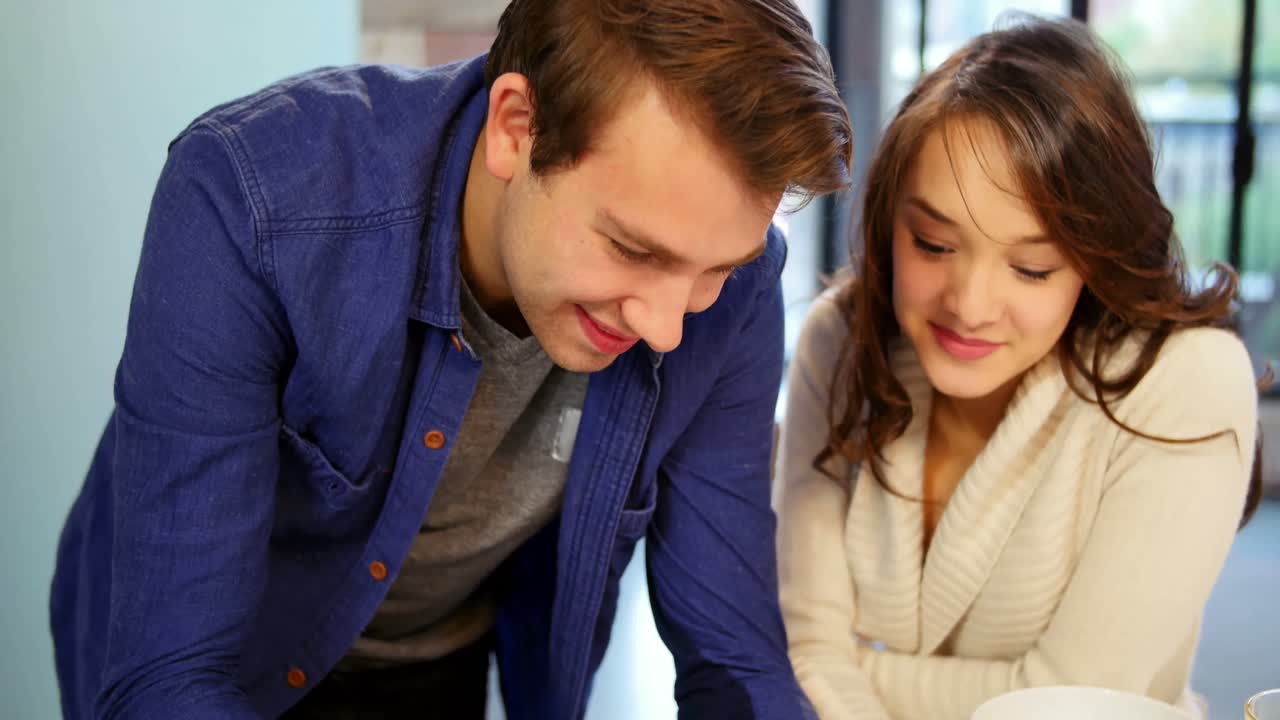 pareja interactuando mientras usa una tableta digital en la sala de estar