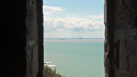 mont saint-michel appears on the horizon from within carol’s cabane, combining normandy’s coastal heritage and natural scenery