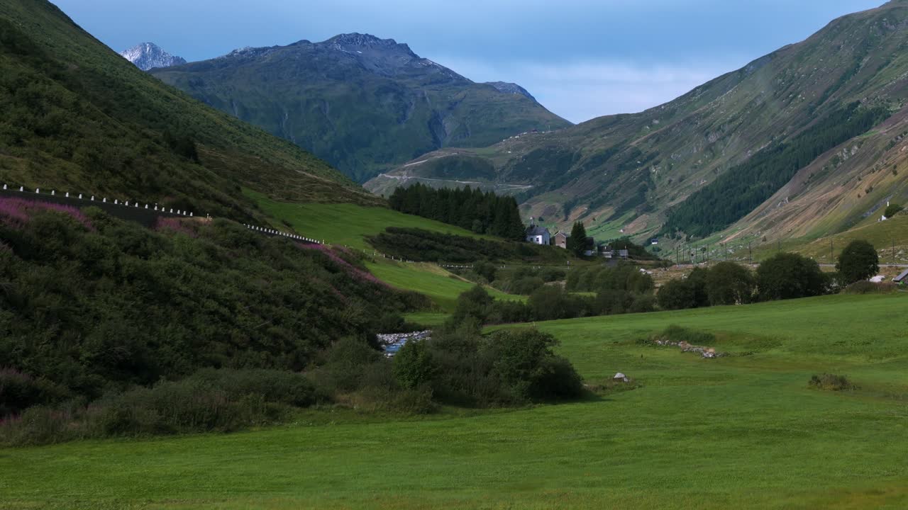 스위스, 여름철 산길에서 자동차와 함께 푸르카 패스의 푸른 초원 위로 상승하는 드론