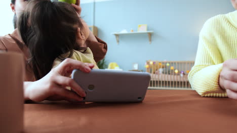 mujer asiática con un teléfono inteligente sentada en una mesa