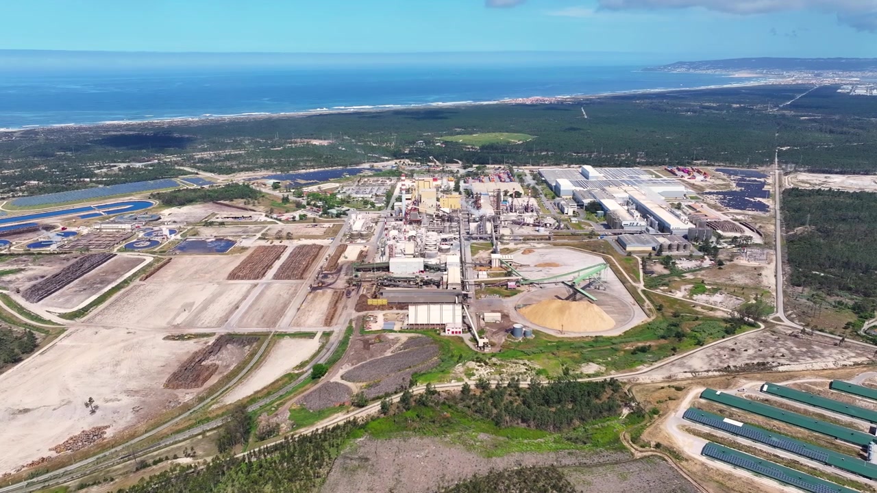 High altitude perspective of a sprawling pulp and paper mill industry. The bioenergy facility processes raw wood materials for cellulose production