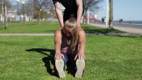 young woman stretching before training in park.