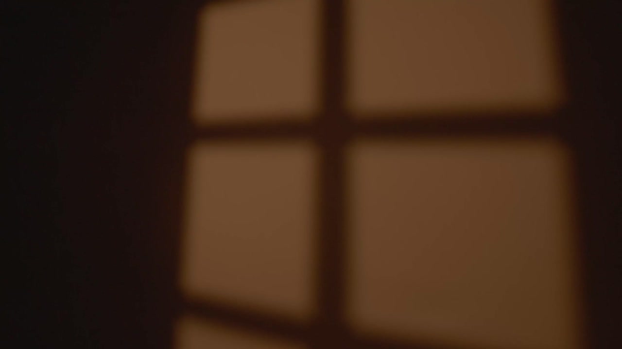 A woman appears to wake up, struck by the sunlight streaming through the window