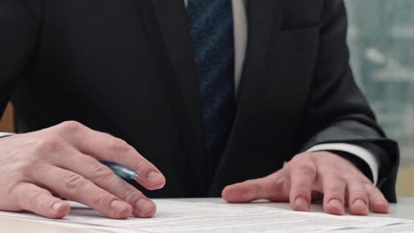 businessman taking notes or signing contract, pen and document, man in formal jacket. close up hand