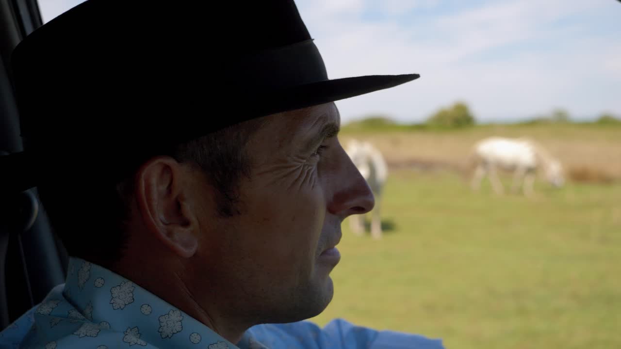 hombre conduciendo junto a su manada de caballos