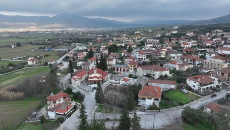 aerial establishing fly above beautiful village with playground and church in greece