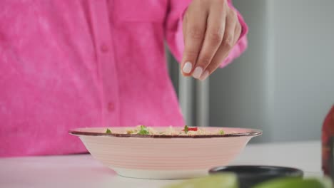agregando sabor a un plato de comida, guarnición de rociado de primer plano como toque final