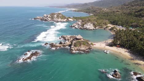 aerial pull out shot of cabo san juan in the sea of tayrona park santa marta colombia