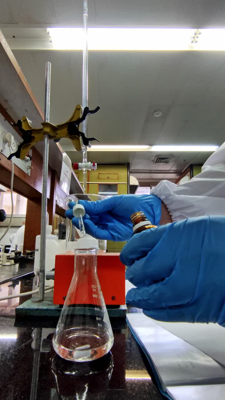 Scientist putting a few drops of phenolphthalein as an indicator on a substance.