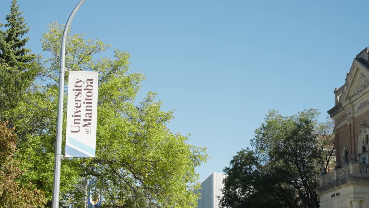 Static shot of University of Manitoba sign on street light during fall