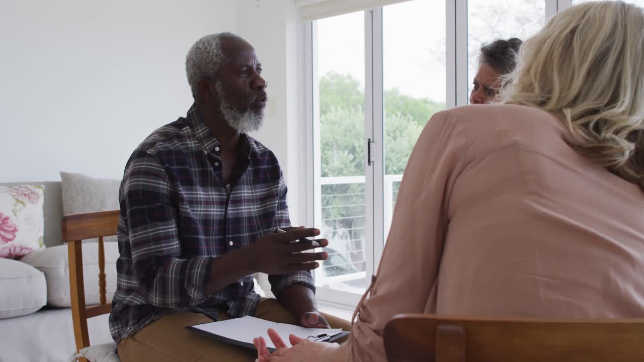 dos parejas de ancianos diversos sentados en círculo teniendo una conversación de terapia en casa