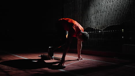 athlete in starting position on a track at night