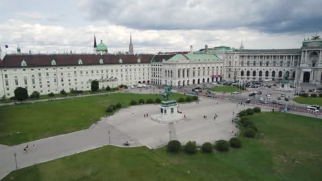 drone establishing orbit of heldenplatz and hofburg palace in vienna, austria with tourists roaming grounds