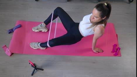 chica haciendo deportes en casa con un entrenador de fitness en línea