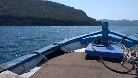 a pov video of a small boat used to transport passengers and cargo,traveling towards a small island