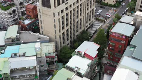 Toma-Aérea-Inclinada-Hacia-Arriba-Con-Vistas-A-Alta-Densidad-Con-Alto-Contraste-De-Edificios-Residenciales-Modernos-Y-Antiguos-Y-Bloques-De-Viviendas-En-El-Centro-De-Yongchun,-Distrito-De-Xinyi,-Capital-De-Taipei,-Taiwán