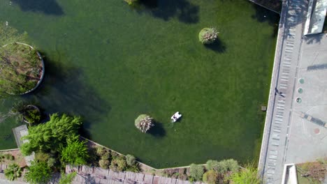 Vista-De-Arriba-Hacia-Abajo-A-Lo-Largo-De-La-Laguna-Con-Crucero-En-Bote-De-Pedales-En-La-Superficie-Del-Agua-El-Parque-Quinta-Normal,-Santiago