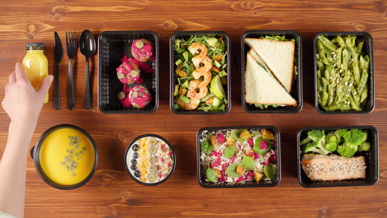 Surtido de recipientes saludables para preparar comidas sobre una mesa de madera